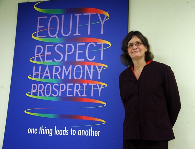 picture of Susan Gapka, in front of equity, respect, harmony prosperity, one thing leads to another poster, photographer Tania Liu, February 2009
