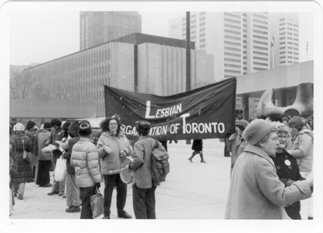 Image description: a photo of a large banner that reads Lesbian Organization of Toronto, from the 1980 International Women’s Day March. Photo by Joan Anderson.
