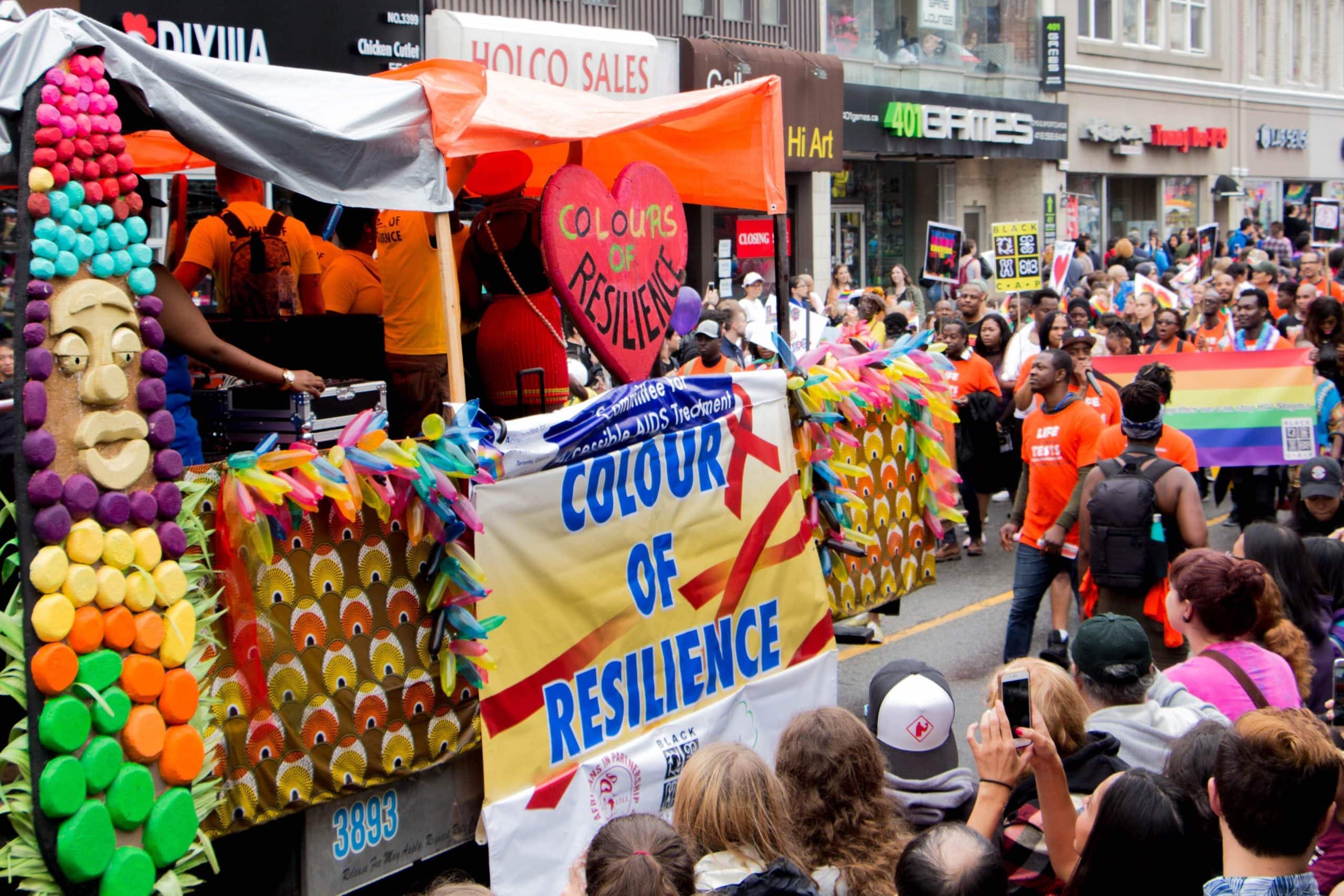 By Asha Collins, Parade Day; June 24 - This particular float depicts the theme of Pride 2018 of the celebration of 35 of HIV & AIDS activism. The banner across the float reads “Colour of Resistance”. The Red Ribbon for HIV and AIDS awareness in the background of the banner.