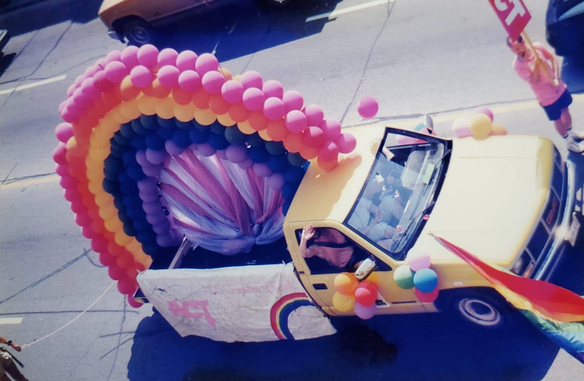 yellow truck with balloons in the shape of a rainbow