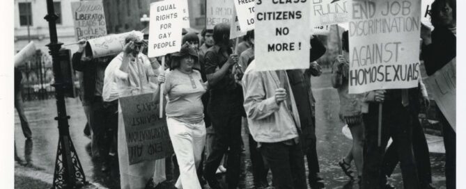 Demonstrators hold signs with text including: “3rd class citizens no more!” and “End job discrimination against homosexuals.”